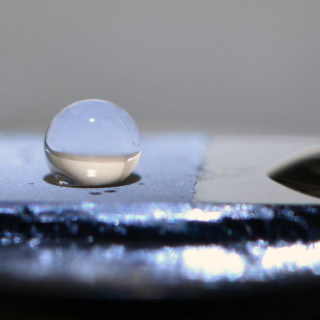 Vattendroppar på en kiselyta, där vänstra sidan är behandlad med en biologiskt nedbrytbar polymer. Foto: Andrew Marais